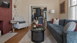A living room with a sofa, armchair, coffee table, and a fireplace. - Boutique Italian Village | OSU | 4BR | + 2 parking (Columbus)