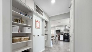 A modern kitchen with white cabinetry, a black stove, and a dining area with a table and chairs. - Walk to Downtown, Hot Tub, Game Room, Boat Parking (Branson)