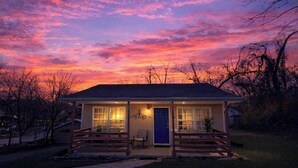 A small house with a porch, a blue door, and a light on the porch. - Walk to Downtown, Hot Tub, Game Room, Boat Parking (Branson)