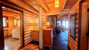 L’intérieur d’une cabane en rondins comprend un espace cuisine, un coin repas et un espace de vie.