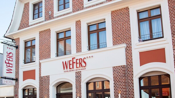 A multi-story building with a prominent sign for 'WEFERS HOTEL, BISTRO, RESTAURANT' on the facade. - Hotel & Restaurant Wefers (Emsdetten)