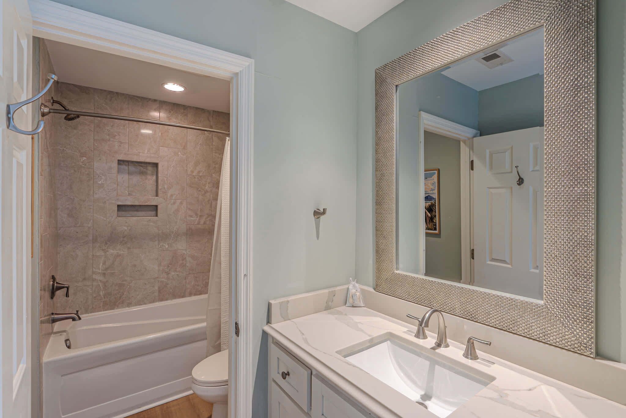 A bathroom with a bathtub, toilet, and sink.