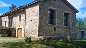 Un bâtiment en pierre avec une porte en bois, un petit balcon et une fenêtre.