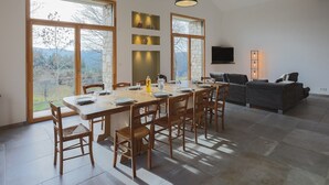 Un espace repas comprenant une grande table et des chaises, un canapé et un téléviseur.