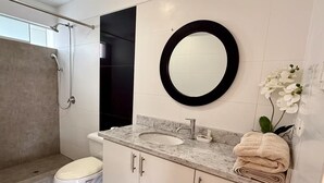 Un baño moderno con inodoro, lavabo y ducha.