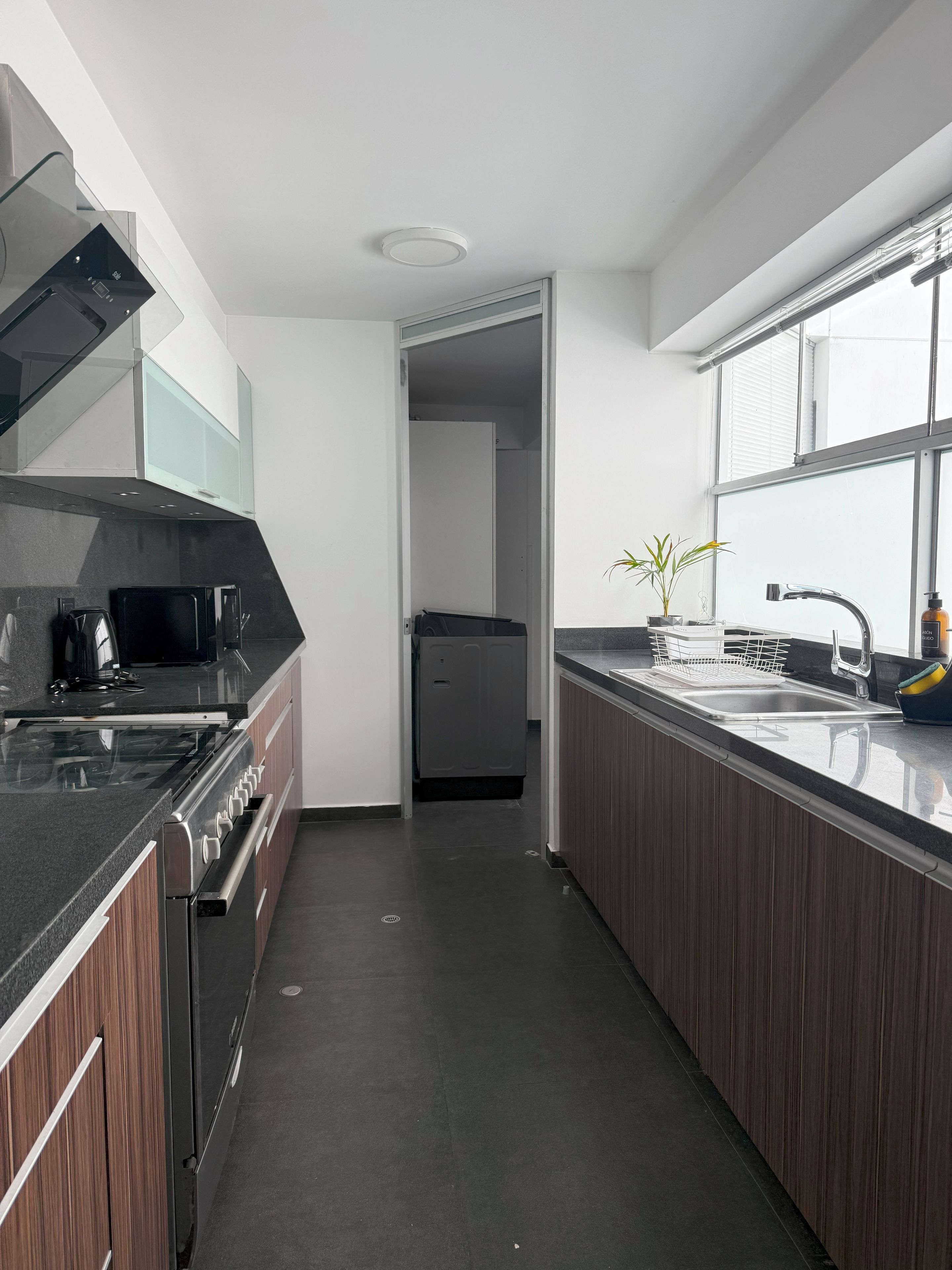 Eine moderne Küche mit eingebautem Backofen, Mikrowelle und Geschirrspüler.