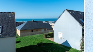 Ein Wohngebiet mit Häusern, einem Rasen und Blick auf das Meer.