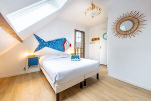 A bedroom with a skylight, a bed, a wall-mounted mirror, and a decorative fish sculpture. - La Cour du Moulin - Proche Plage (Houlgate)