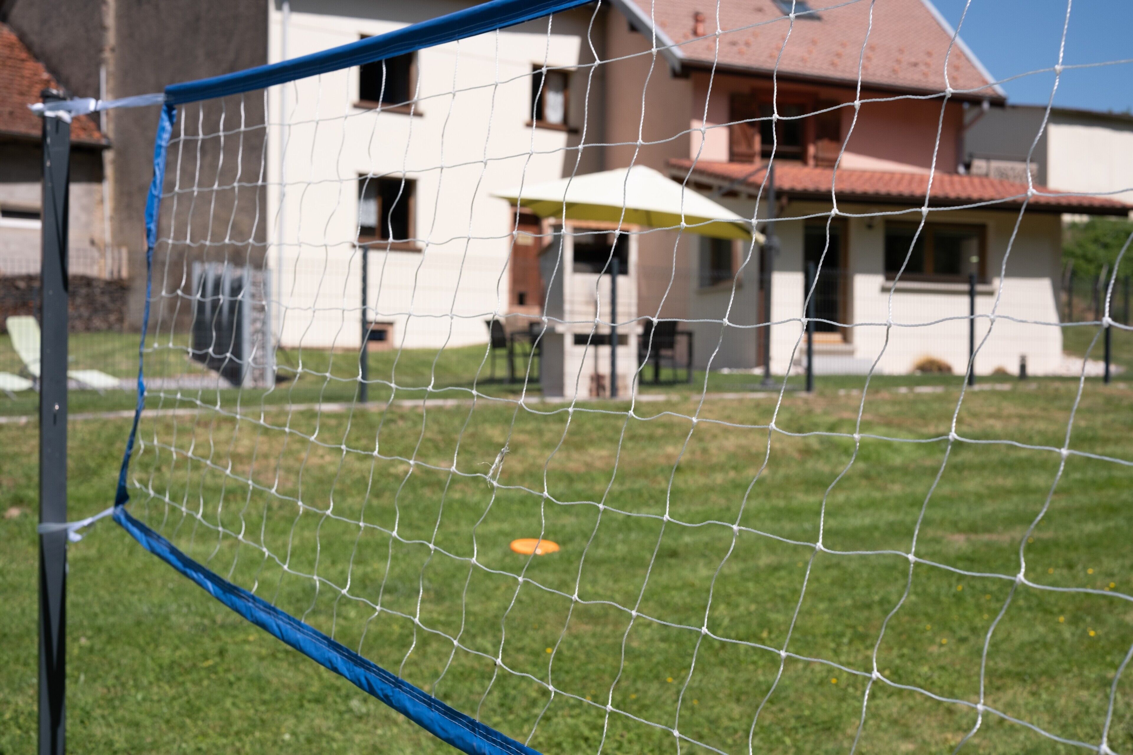 Un'area giochi recintata con una casetta sullo sfondo.