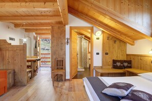 Un interno in legno con un letto, una sedia, un tavolo e una panca.