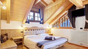 A wooden bedroom with a bed, bedside tables, a window, and a TV. - Maso di Zonadi – Alpine House in the Heart of Val di Rabbi (Rabbi)