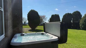 Un jacuzzi junto a un edificio con vistas amplias del paisaje circundante.