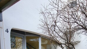 Ein modernes Haus mit Glastür, einer Holztreppe und einem kleinen Garten.