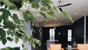 A modern living room with a sofa, a coffee table, and a ceiling fan. - Guest Favorite · Large Lux Rooftop Oasis House  · 4BR · Centrally Located! (Berry Hill)
