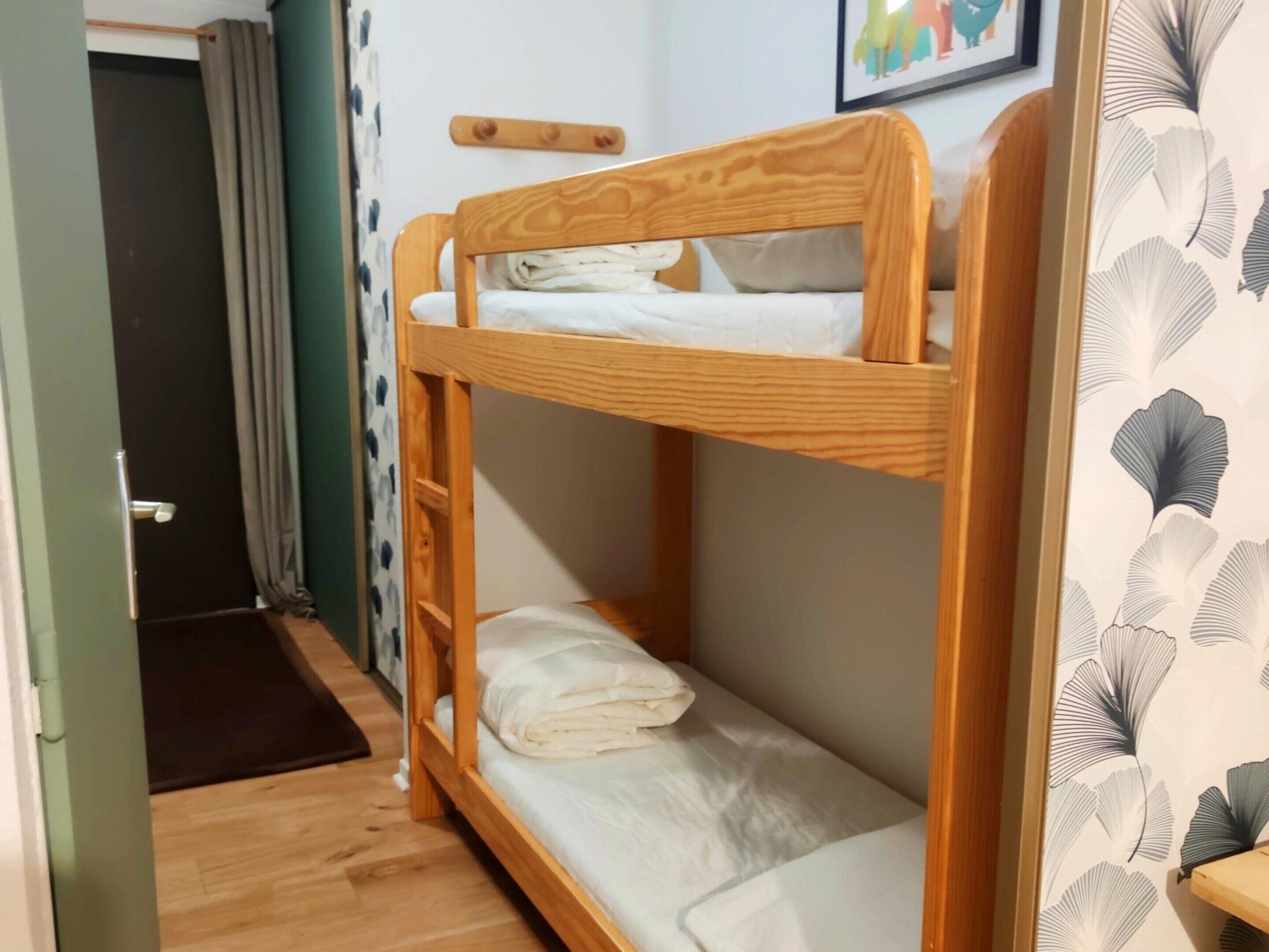 A bunk bed with a wooden headboard and a lower bunk.