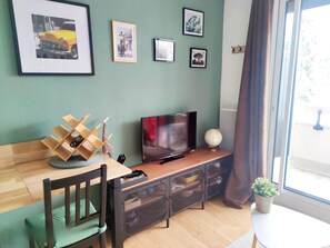 A living room with a TV, wooden furniture, and framed pictures on the wall. - Les Marmottes Ndeg112 - ST5 (Chamrousse)