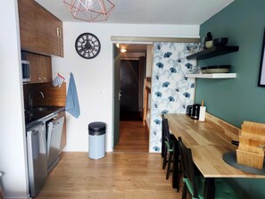 A kitchen with wooden cabinets, a sink, a stove, and a trash can. - Les Marmottes Ndeg112 - ST5 (Chamrousse)
