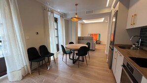 Una cocina moderna con horno empotrado y un comedor con mesa redonda y sillas.