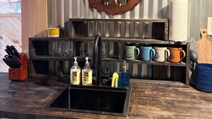 Maalaishenkinen keittiö, jossa on Route 66 -kyltti, pesuallas ja erilaisia keittiötarvikkeita.