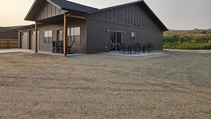 Een modern gebouw met twee verdiepingen, een overdekte patio en buiten zitplaatsen.