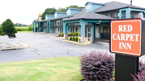 A Red Carpet Inn with a parking lot and a McDonald's sign in the background. - Red Carpet Newnan (Newnan)