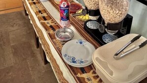 Ein Frühstücksbuffet mit Kaffeemaschine, Müslidosen und einer Flasche Limonade.