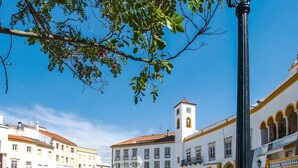 A cobblestone plaza with buildings, a clock tower, and a street lamp. - Apartment 'O Meu Cantinho' with Wi-Fi and Air Conditioning (Elvas)