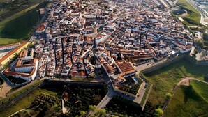 An aerial view of a historic town with a fortified wall, narrow streets, and a mix of residential and commercial buildings. - Apartment 'O Meu Cantinho' with Wi-Fi and Air Conditioning (Elvas)