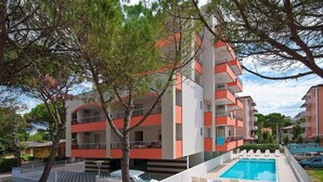 Ein mehrstöckiges Hotel mit Schwimmbad, Außenbereich und Fußgängerweg.