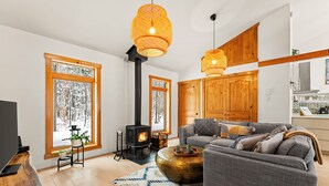 Ein modernes Wohnzimmer mit Kamin, großen Fenstern und einem gemütlichen Sofa.
