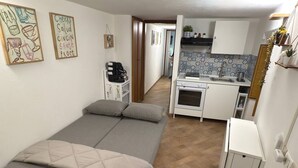 A compact room with a bed, kitchenette, and a small bathroom. - In the heart of Palermo, cozy apartment in the Historic Center. (Palermo)