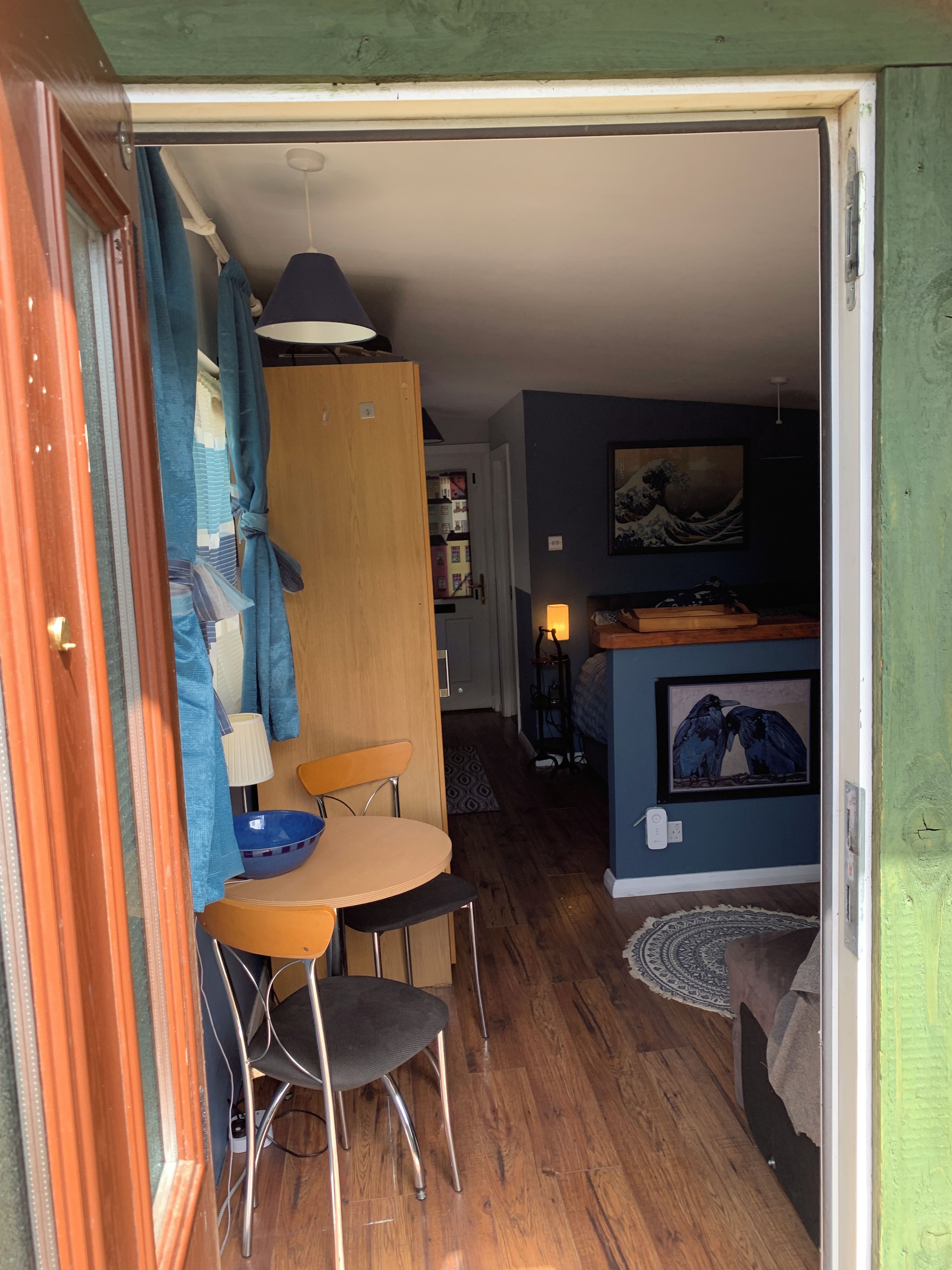 A compact living space with a dining area, a kitchenette, and a bedroom.