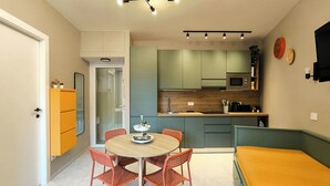 Una cucina compatta con zona pranzo, un forno a microonde e un lavandino.
