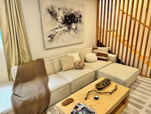 Un soggiorno moderno con un divano componibile, un tavolino in legno e un quadro appeso al muro.
