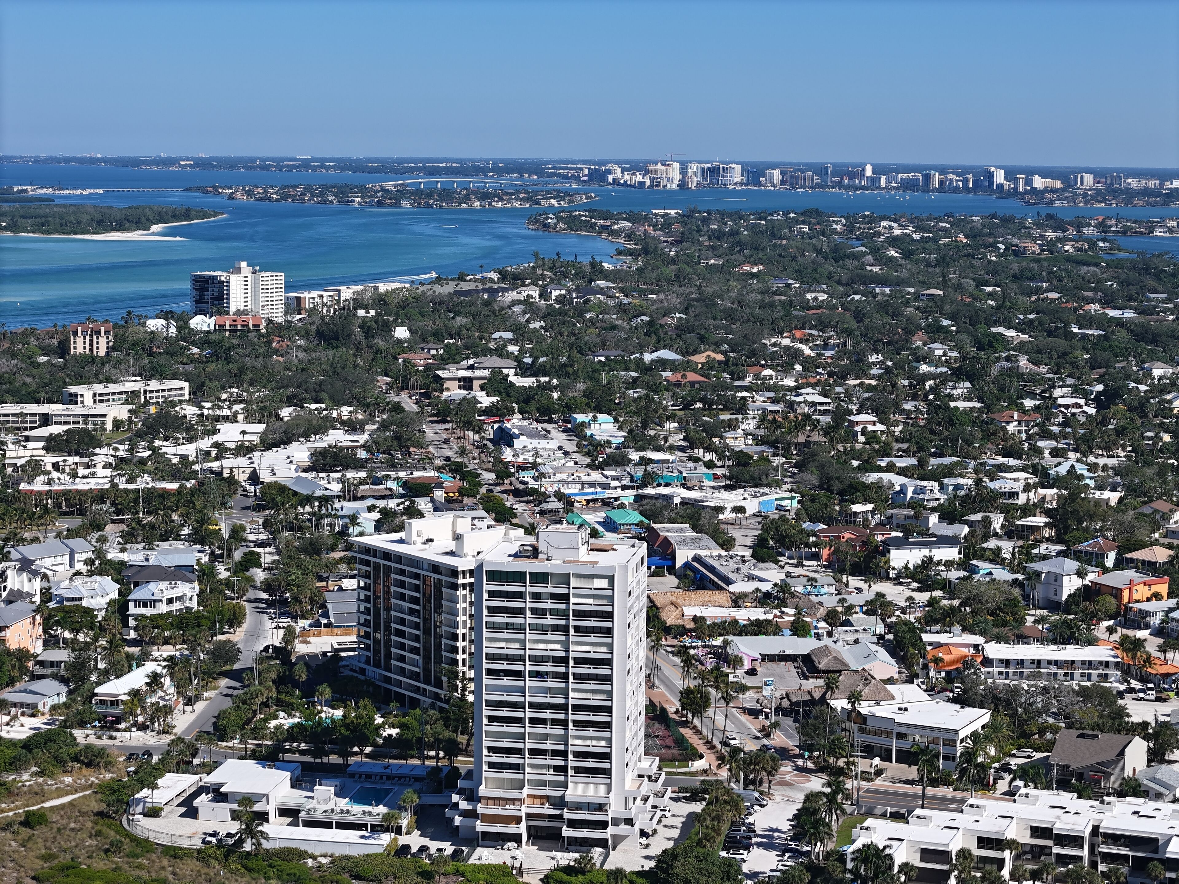 A high-rise hotel with multiple floors, surrounded by a dense residential area with various buildings and greenery.