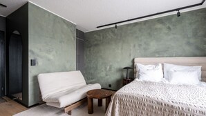 Ein Schlafzimmer mit Bett, Stuhl, Nachttisch und Lampe.
