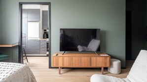 Ein modernes Schlafzimmer mit einem Holzkasten, einem Fernseher und einem Bett.