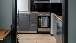 Eine moderne Küche mit eingebautem Backofen, Mikrowelle und einer schwarzen Dunstabzugshaube.