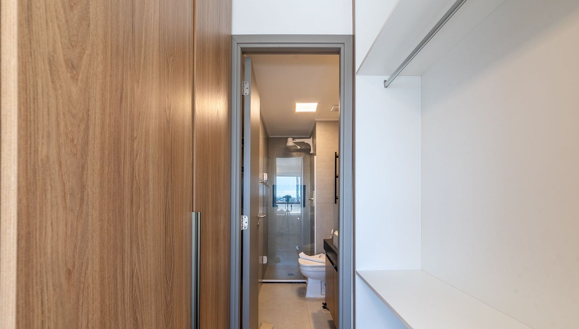 A modern bathroom with a glass shower enclosure, a toilet, and a sink.