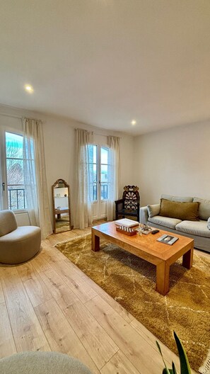A living room with a wooden coffee table, a sofa, a chair, and a mirror. - Town house (Auray)
