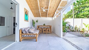 A modern interior with a wooden ceiling, a sofa, a dining table, and a small garden area. - Cool house with Pool at only steps from the Beach and Surf (Carmen Beach)