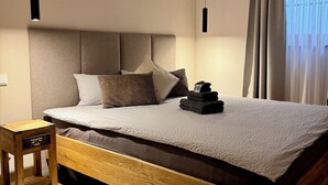 Un dormitorio moderno con cabecera de cama de madera, una mesita de noche y una lámpara de noche.