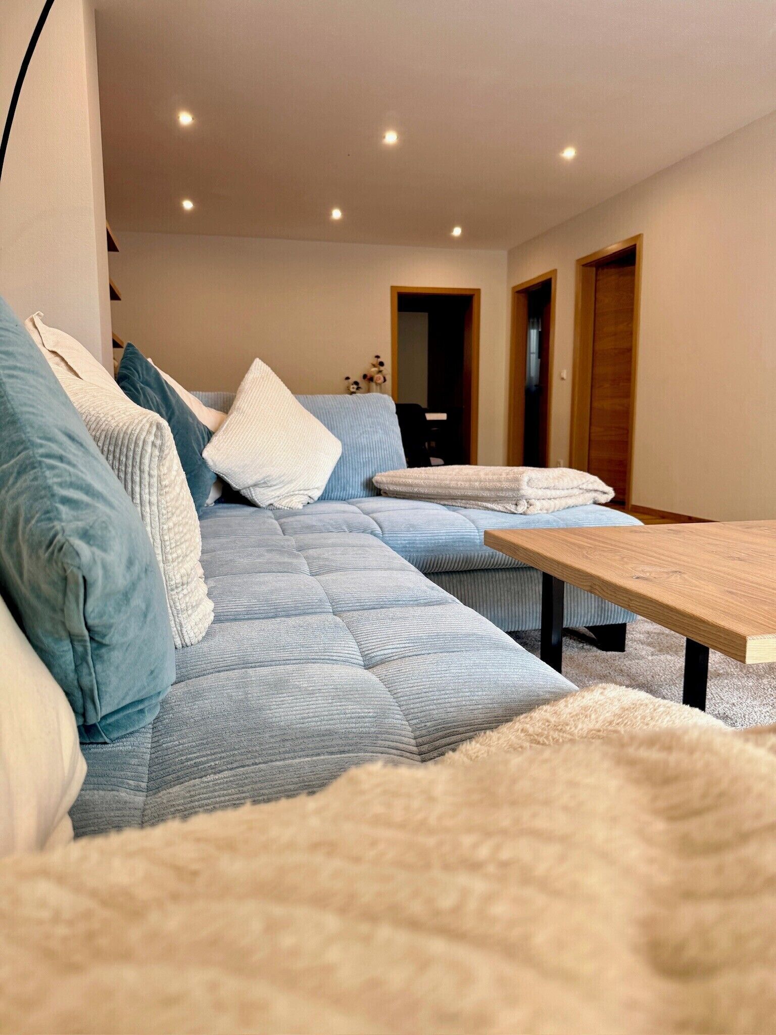Un salon moderne avec un canapé, une table basse et un tapis moelleux.