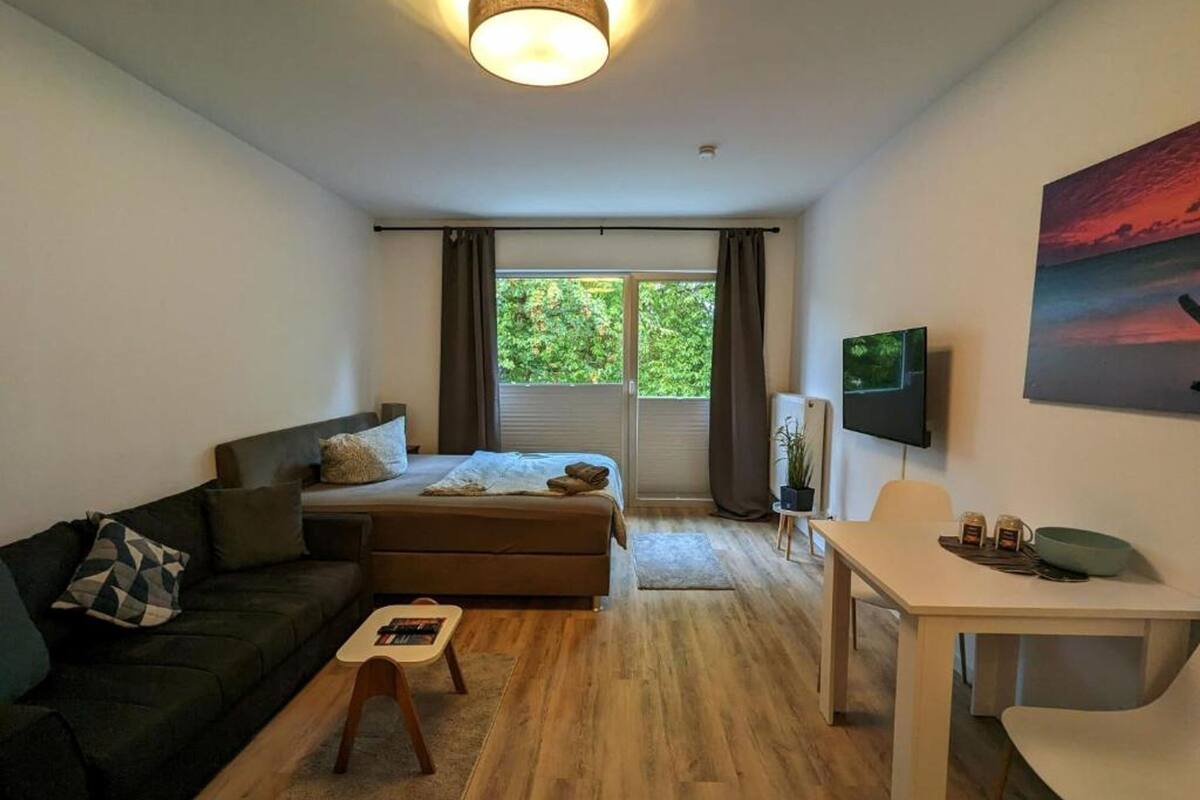 Une chambre à coucher moderne avec un lit, un canapé, une petite table et un bureau.