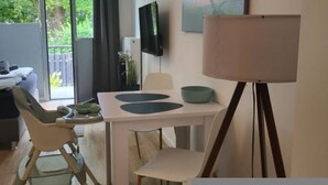 Una sala de estar moderna con comedor, un ventanal grande y un cuadro en la pared.