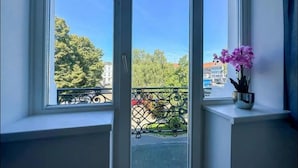 A room with a large window overlooking a balcony with a metal railing. - Infinity Stay: Nordsee Apartments (Wilhelmshaven)