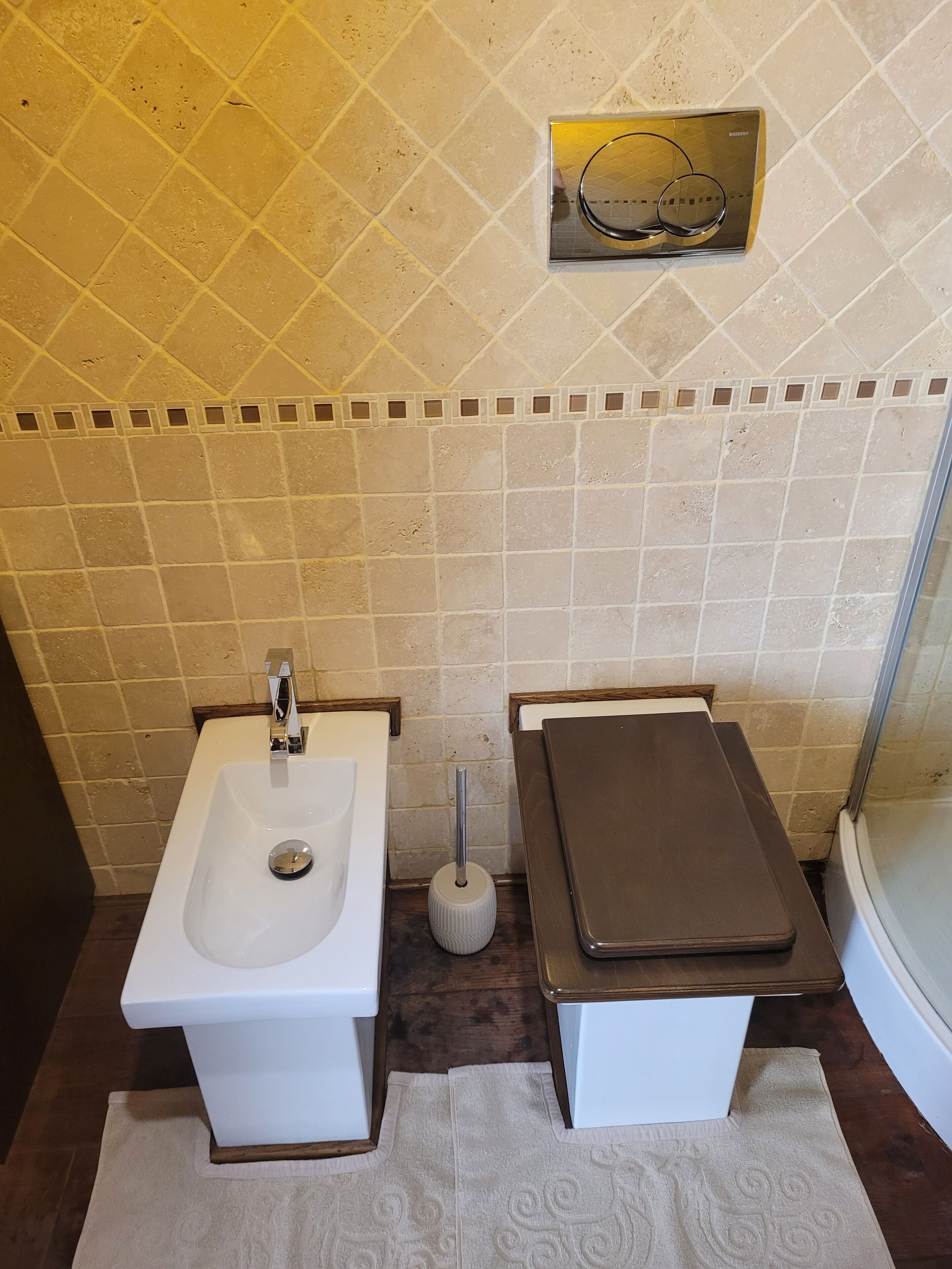 Une salle de bain équipée d’un bidet, de toilettes, d’un porte-serviettes et d’un miroir.