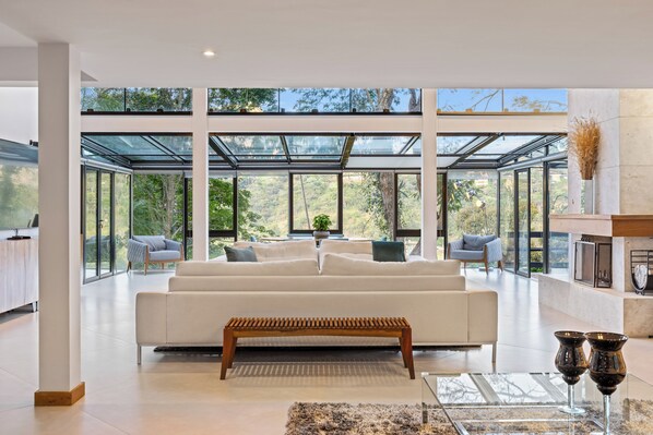 A modern living room with a white sofa, a wooden bench, and a glass coffee table.