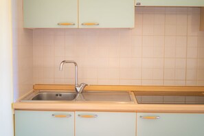 Kjøleskap, kokeplater, kjøkkenutstyr og spisebord