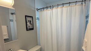 A bathroom with a sink, toilet, and shower curtain.